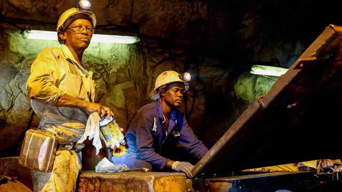 Two people equipped with headlights in a mining site