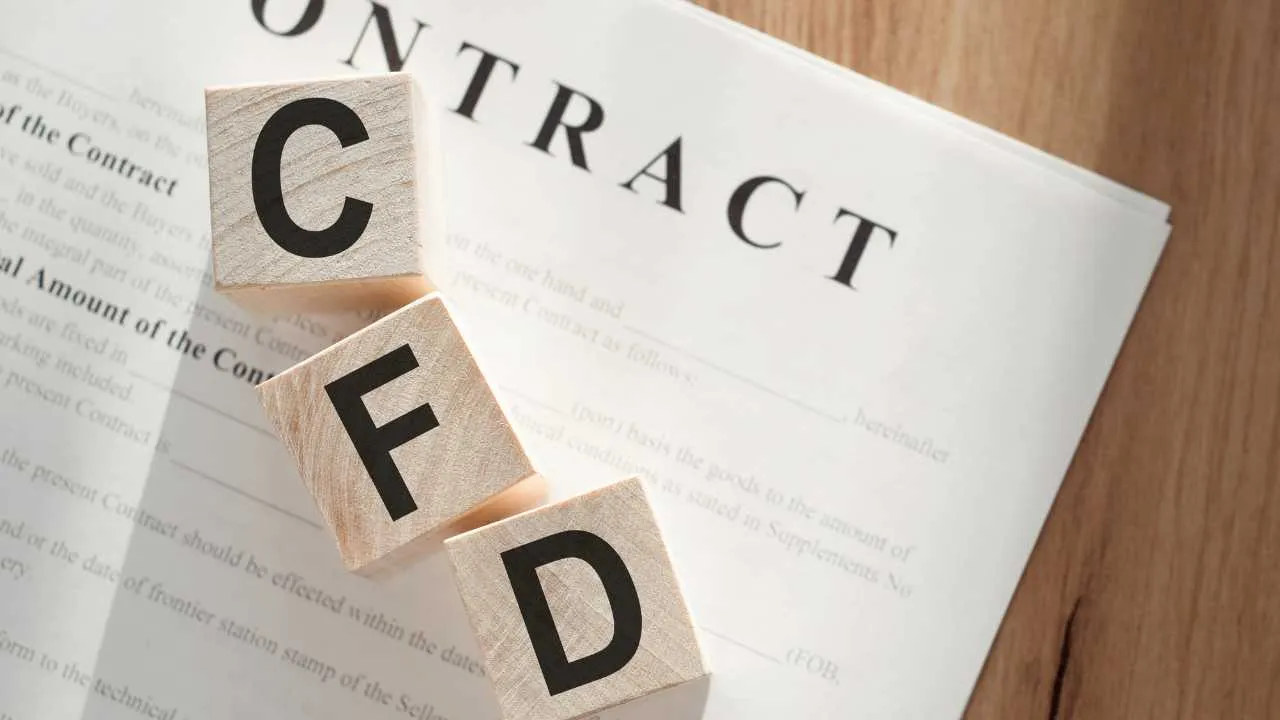 Wooden blocks spelling "CFD" on a contract paper