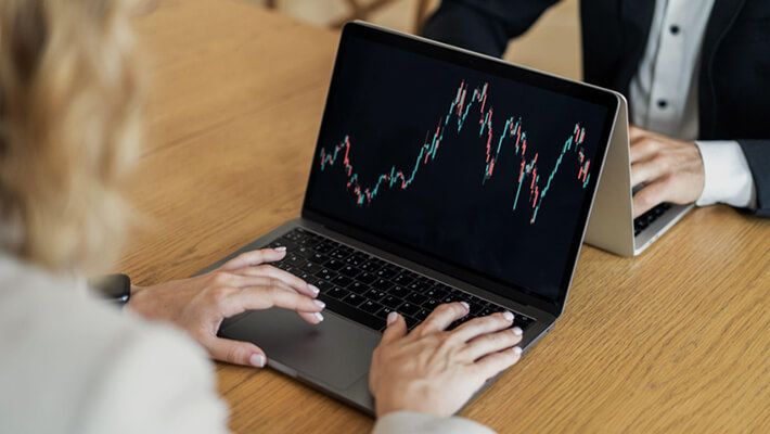 two person trading ETFs on their laptops