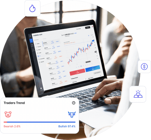 A person in a meeting holding a laptop showing a graph of different commodities. Traders Trend showing Bearish in 2.6% and Bullish in 97.4%.