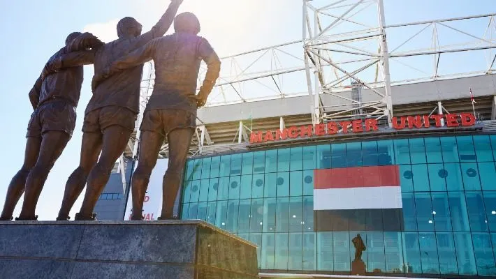 a statue of two men in front of a stadium