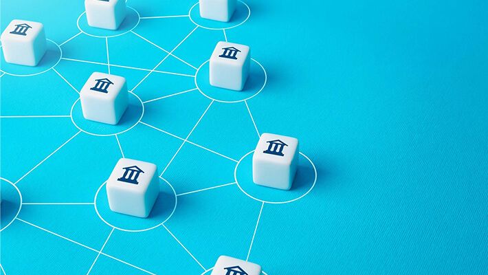 white cubes, each bearing bank icons, neatly aligned on a blue tabletop.